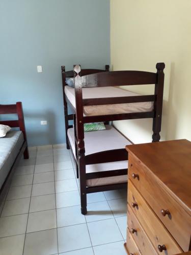 佩鲁伊比CASA DO PESCADOR的一间卧室配有双层床和木制梳妆台