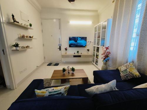 班加罗尔Anvaya Tranquility的客厅配有蓝色的沙发和桌子