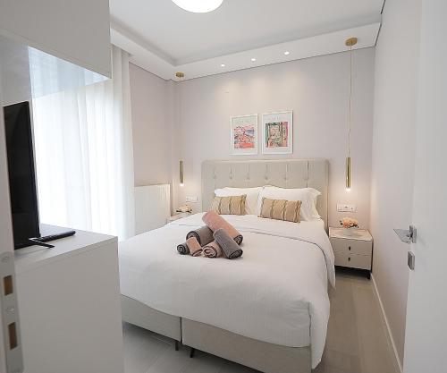 卡斯托里亚Sam Casa Luxury Living的白色的卧室配有一张白色的大床和电视。
