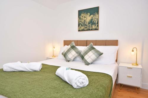 桑德巴奇Chapel House, Where Comfort Meets Convenience - BOOK NOW!的一间卧室配有一张带绿毯和枕头的床。