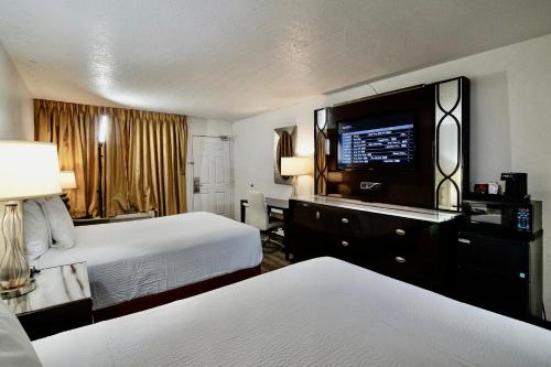 优马Ramada by Wyndham Yuma的酒店客房设有两张床和一台平面电视。