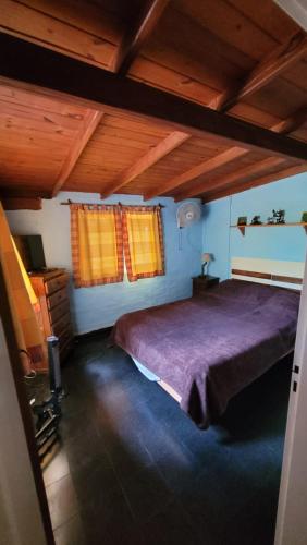 圣罗莎卡拉穆奇塔县Hakuna Matata的一间卧室配有一张大床和紫色毯子