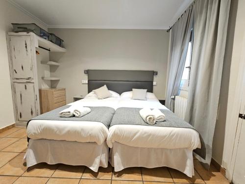 托莱多拉坎帕纳旅馆的一间卧室配有一张大床和毛巾