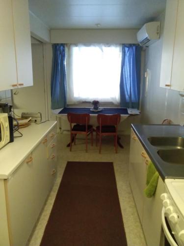 萨拉Karhunkierrospysäkki的厨房配有水槽和一张带窗户的桌子