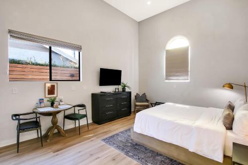 圣巴巴拉Villa Castillo 3的一间卧室配有一张床、一张书桌和一台电视。