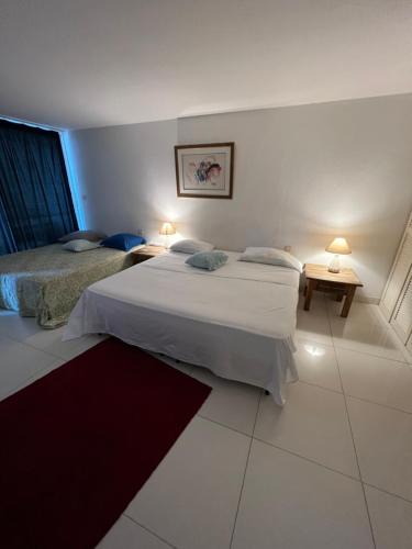 东方湾法国大街Suite Résidence Mont Vernon的酒店客房设有两张床和两盏灯。