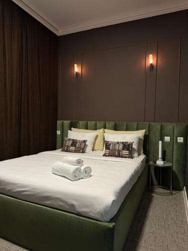 阿克托比Hotel NOMAD的一间卧室配有一张大床和绿色床头板