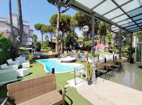 米兰马瑞提那Hotel Europa Milano Marittima的一个带游泳池和桌椅的度假酒店