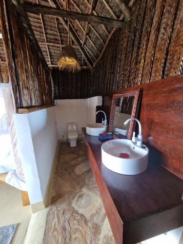 MtendeMtende Beach Bungalow océan view的一间带两个盥洗盆和卫生间的浴室