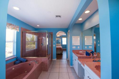 安娜玛丽亚Casa Muratti的浴室设有蓝色的墙壁、两个盥洗盆和浴缸。