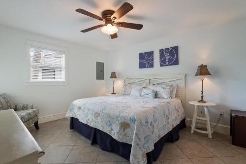 霍姆斯海滩Beach Isle的一间卧室配有一张带吊扇的床