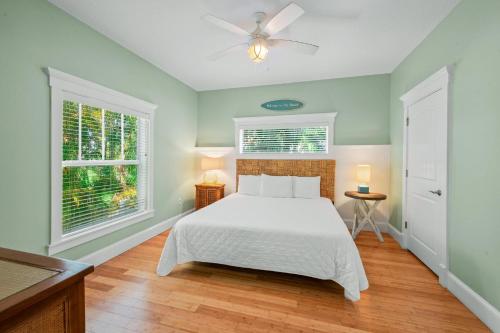 霍姆斯海滩Gulfside Oasis的卧室配有白色的床和2扇窗户。