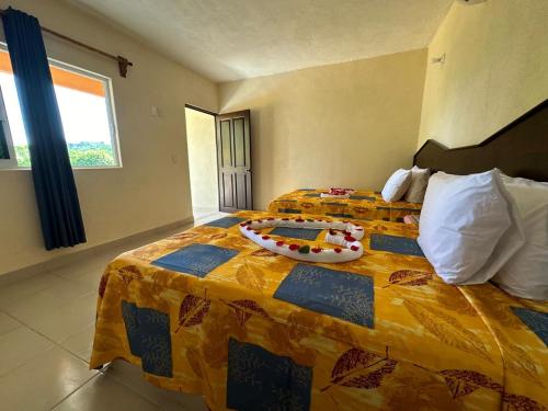 锡瓦塔塔内霍Hotel Posada Purépechas的酒店客房设有两张床和一张色彩缤纷的床罩