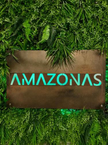 圣玛丽亚港Puerto Amazonas apartamento con jacuzzi privado的植物墙上的亚马逊标志