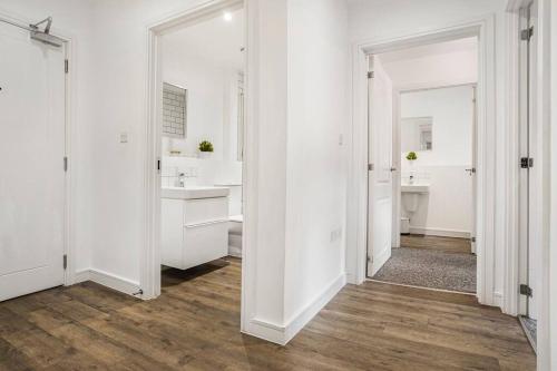 伯明翰Oceanic Bliss: 2 BED 2 BATH + FREE PARK + Netflix的白色的浴室设有两个盥洗盆和镜子