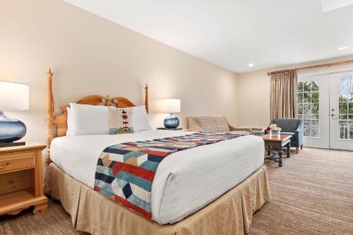 萨格港Sag Harbor Inn的一间大卧室,配有一张大床和一把椅子