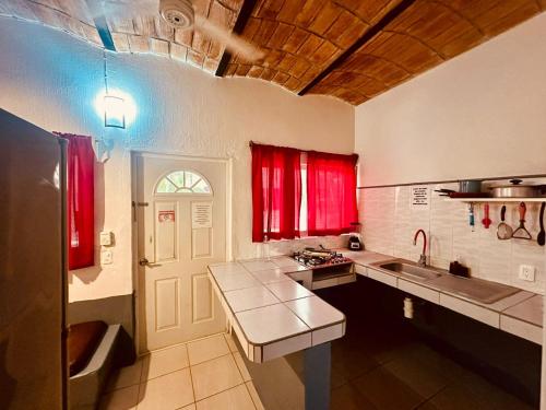 瓜亚比托斯Bungalows Las Glorias的厨房设有红色窗户和台面
