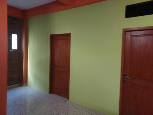 普兰巴南kost maqmil的一间卧室设有绿色的墙壁和木门。