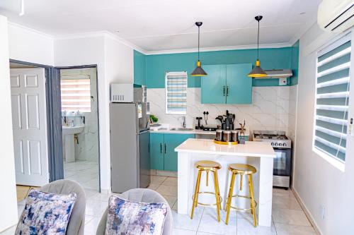 比勒陀利亚Homes of Ace Gold的厨房配有蓝色橱柜和2个酒吧凳