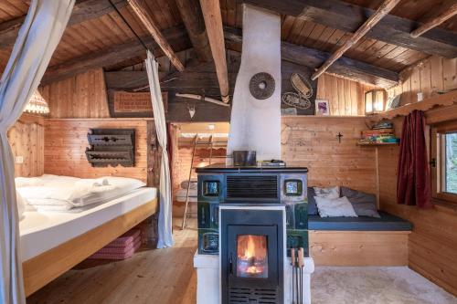 迈尔霍芬Kitzkopf Hütte的一间带炉灶的卧室和一张位于客房内的床。