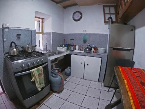 库斯科MORENAS BACKPACKERs的厨房配有炉灶和冰箱。