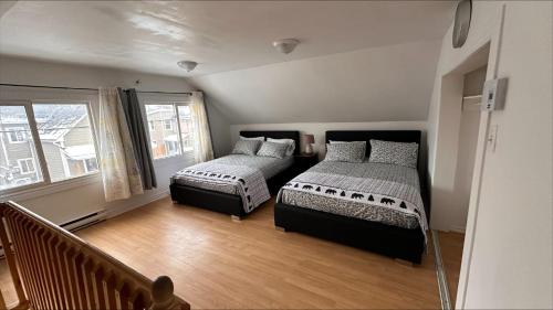 加蒂诺Le Cent Onze的一间卧室设有两张床和窗户。