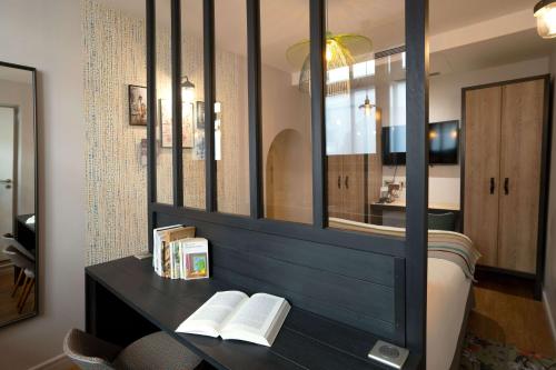 巴黎Hotel Litteraire Marcel Ayme, BW Premier Collection的一间带镜子的卧室和一张带书籍的床