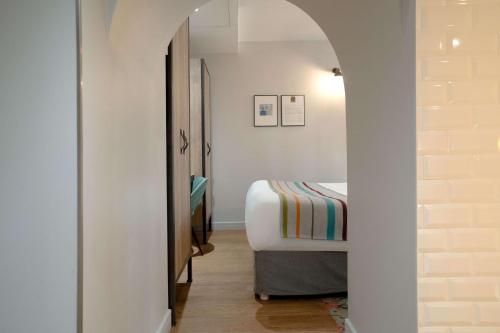 巴黎Hotel Litteraire Marcel Ayme, BW Premier Collection的一间小卧室,配有一张床和一个走廊
