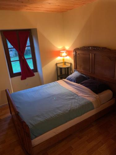 Saint-LambertLieu dit le jardin的一间卧室配有一张带灯和窗户的床