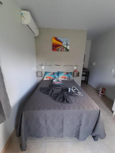巴拉那州蓬塔尔Mini Casa Chácara Zulin's - AMOR E ACONCHEGO的一间卧室配有一张带灰色床罩的床