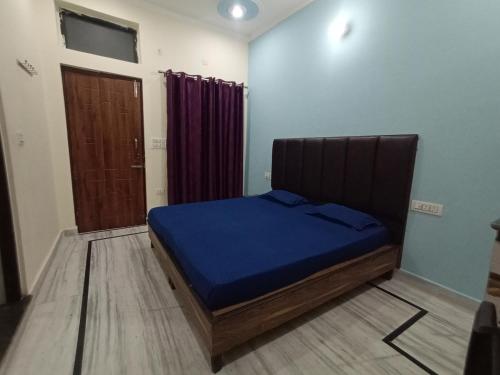 瑞诗凯诗Deepak Homestay的一间卧室配有一张带蓝色床单的床和一扇门。