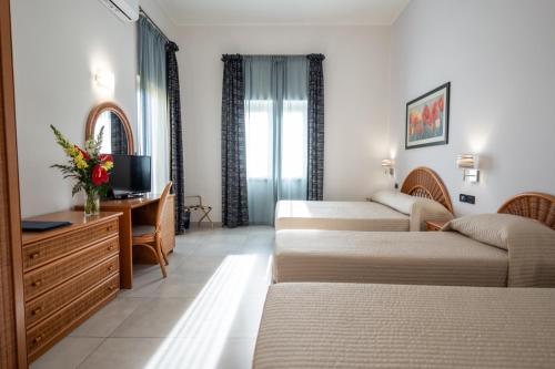 陶尔米纳科拉罗酒店的酒店客房设有三张床和一张书桌
