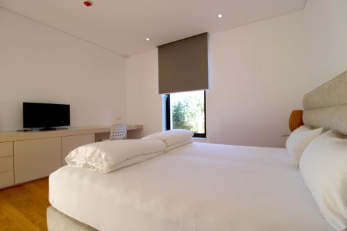 都拉斯Deluxe Villa Jante Infinity Pool的白色卧室配有一张带枕头的大白色床