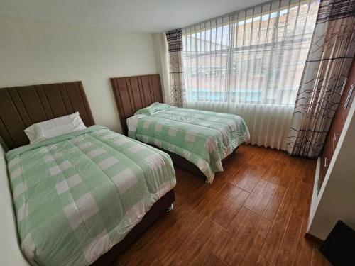 阿雷基帕Casa familiar en Arequipa的一间卧室设有两张床和窗户。