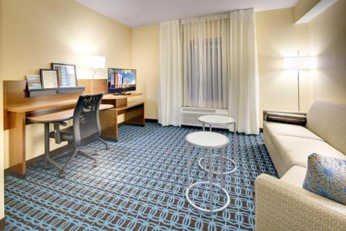 阿什维尔Fairfield Inn & Suites by Marriott Asheville Tunnel Road的带沙发和书桌的酒店客房