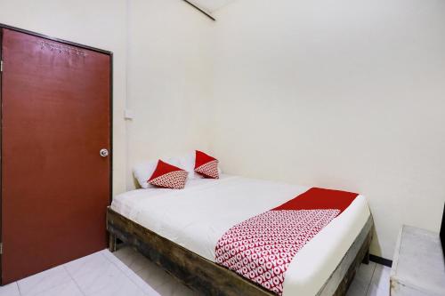 JodohSPOT ON 91422 Ringin Pitu 2 Syariah的一间卧室配有红色和白色枕头的床