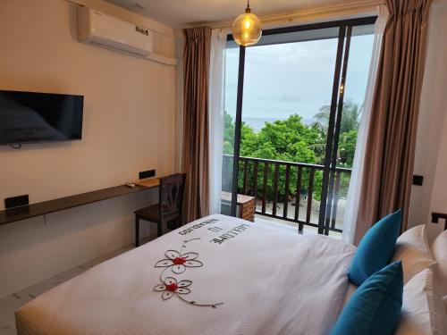 迪古拉Nikabliss Dhigurah的一间卧室设有一张床,享有阳台的景色