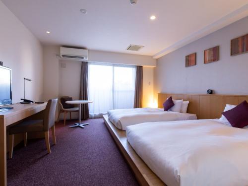 东京门前仲町东急酒店的酒店客房配有两张床和一张书桌