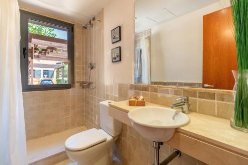 邦蒙特特雷斯诺维斯Casa Bonmont Miami Platja的一间带水槽和卫生间的浴室以及窗户。