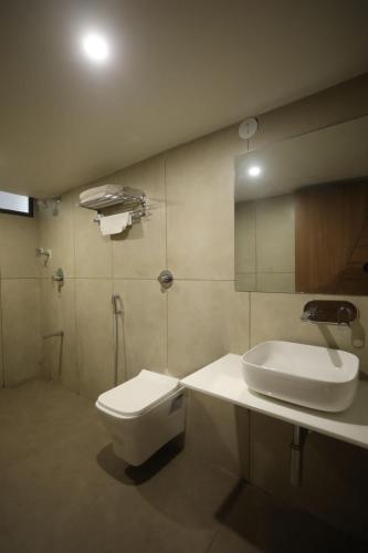 拉杰果德Hotel R City Inn By Mantram Hospitality的浴室配有白色卫生间和盥洗盆。