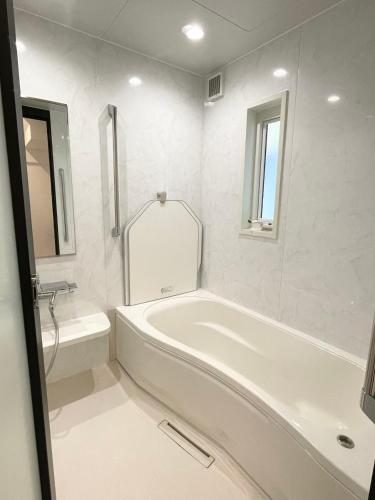 大洲熊本民宿-悠然别苑的白色的浴室设有浴缸和水槽。
