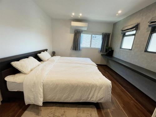 大洲熊本民宿-悠然别苑的卧室设有白色大床和窗户。