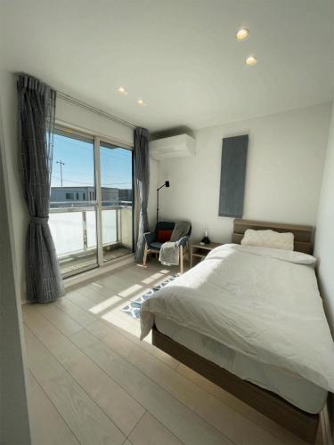 大洲熊本民宿-悠然别苑的一间卧室设有一张床和一个大窗户