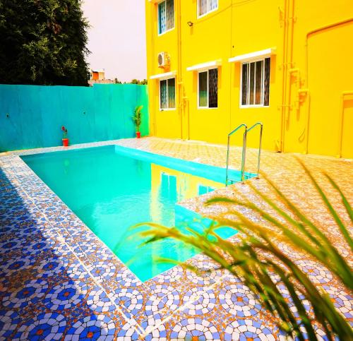 KottakupamAuro Galaxy Pondy with Swimming Pool的黄色建筑前的游泳池
