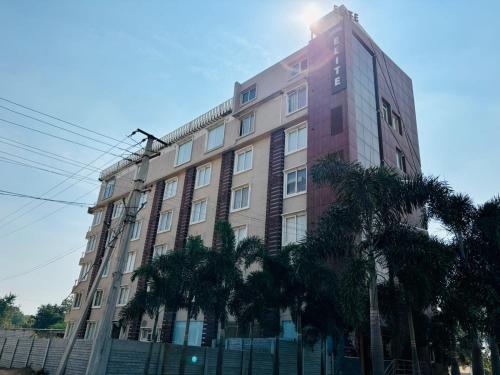 海得拉巴Hotel Elite By Signature Group的一座高大的建筑,前面有棕榈树