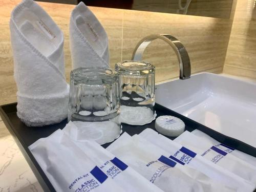 万象ST Hotel Wattay Airport的浴室水槽配有玻璃瓶和毛巾