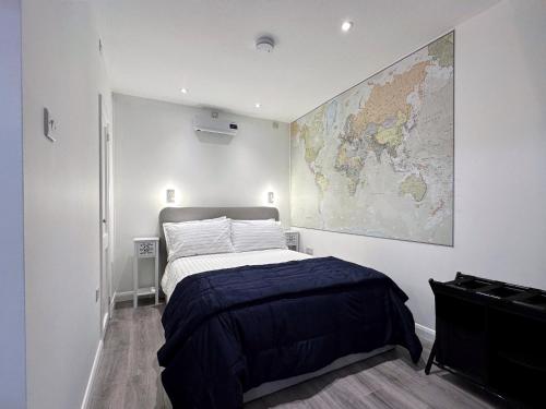 伦敦Kensington Studio hosted by AirOperate的卧室配有一张床,墙上有地图