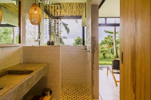 塞隆贝拉纳克Kirikan Villas, Secluded Jungle Paradise的带淋浴的浴室,铺有瓷砖地板。
