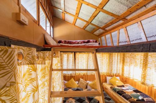 德拉敦Kanasar Jungle Camp & Retreat的带窗户的客房内的两张双层床
