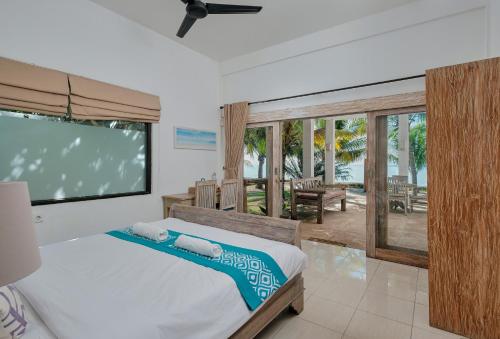 Jereweh米娅莫海滩酒店的一间卧室配有一张床和一台平面电视